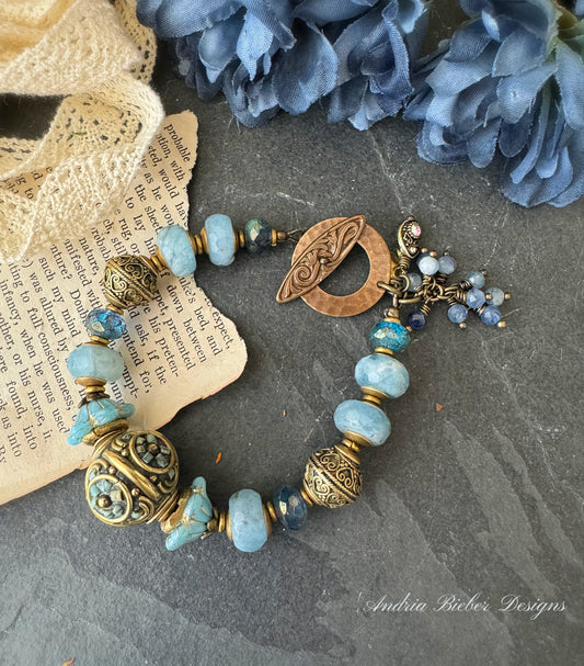 Aquamarine stone, African brass, Czech glass, Indonesian bead with flower detail.